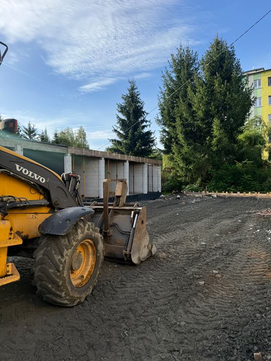 Koparko-ładowarka Volvo na placu przygotowanym pod garaże
